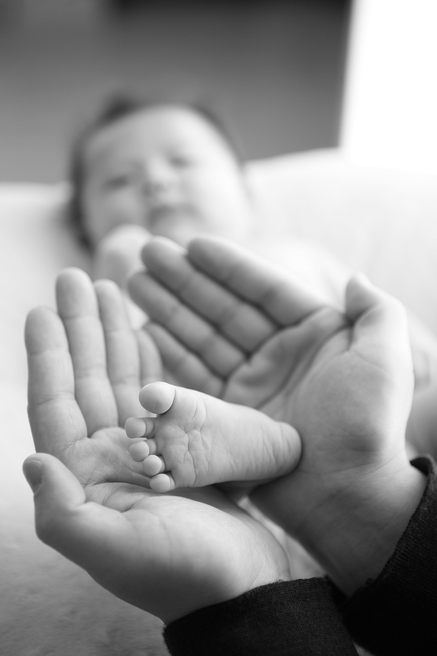 Pied de bébé tenu dans les mains de sa mère