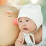 bébé asiatique qui va passer une bonne nuit avec son bonnet de nuit et sa peluche