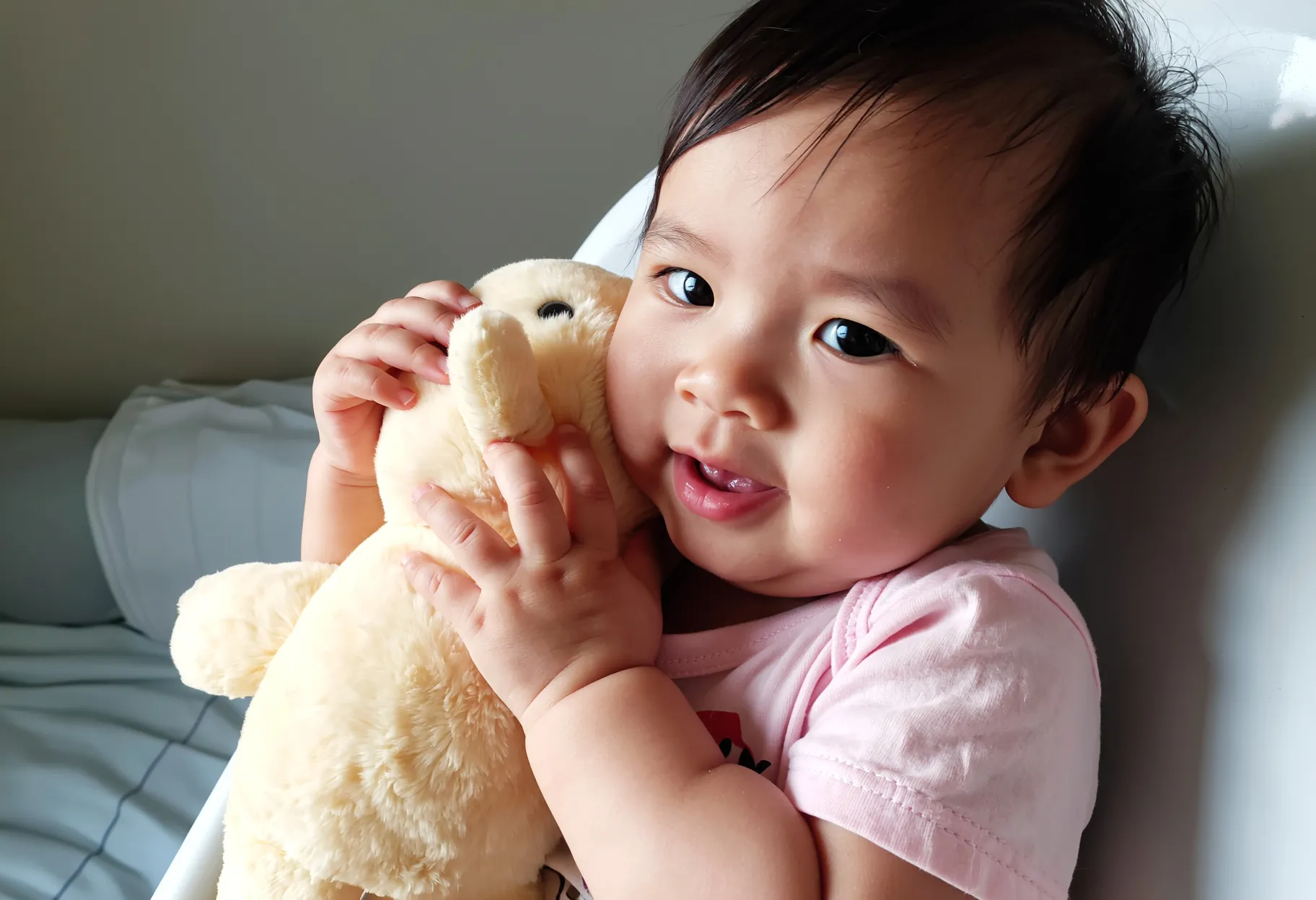 enfant de 18 mois qui câline un doudou en peluche toute douce