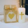 Cadeau symbolique posé à côté d’une bougie de baptême