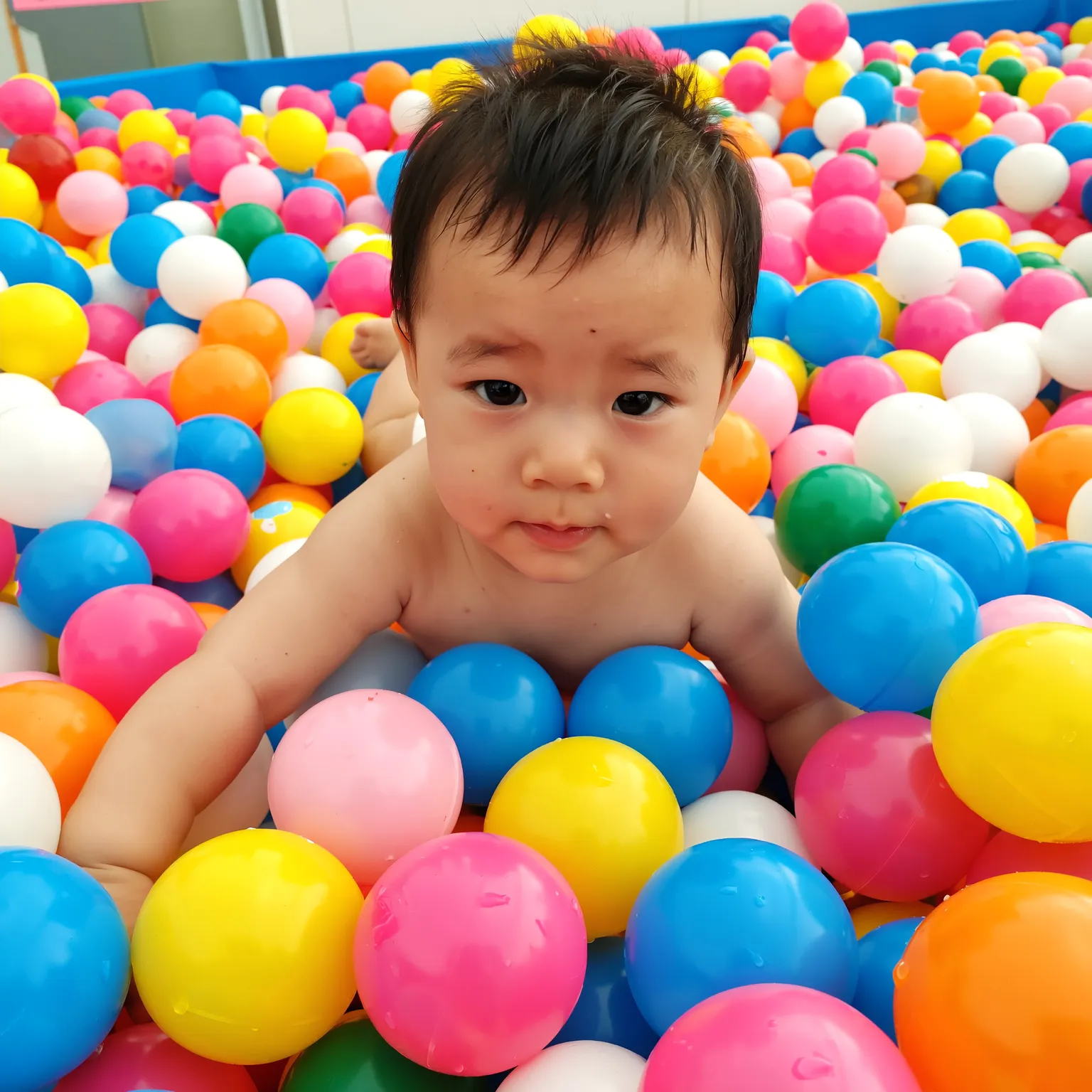 Bébé joue dans une piscine à balles colorées