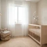 Chambre de bébé épurée avec lit à barreaux en bois clair, mobile suspendu et panier de rangement, lumière naturelle douce