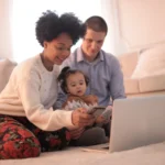 des parents qui accompagnent leur enfant avec un écran dans un salon sainement